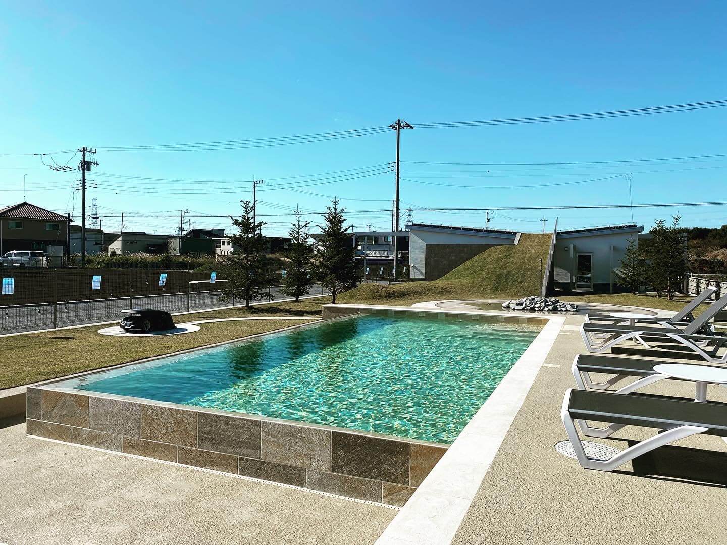 芝生とパラソルに囲まれたマジラインプールの施工事例